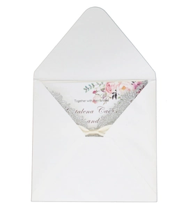 Laser cut floral wedding invitation with silver glitter lace and a beige satin bow