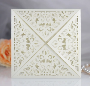 Macro detail of ivory laser-cut lace wedding invitation with elegant floral hollow patterns