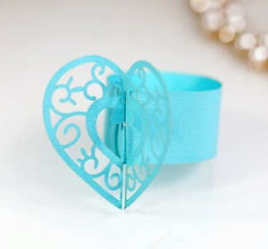 Détail d'un rond de serviette cœur bleu clair découpé au laser avec motif filigrane