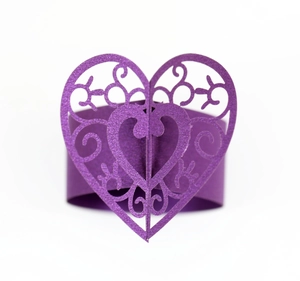Détail d'un rond de serviette cœur violet foncé avec découpes laser et motifs volutes
