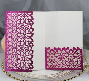 Detail of rose pink laser-cut glitter wedding invitation with mandala pattern and ivory insert