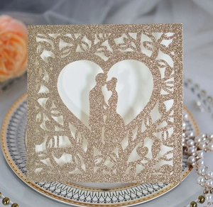 Vue détaillée de l'invitation de mariage pailletée or champagne avec motif cœur découpé
