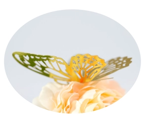 Detail of 3D hollow gold paper butterfly decoration placed on a soft faux flower