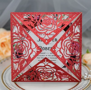 Detailed laser-cut red glitter wedding invitation with elegant rose pattern and white insert