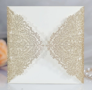 Close-up of laser-cut lace wedding invitation with sparkling gold glitter finish