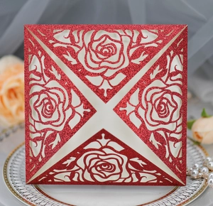 Detail of red glitter laser cut rose wedding invitation with elegant hollow floral pattern