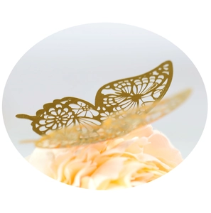 Detailed close-up of a laser-cut golden metal butterfly decoration on a delicate flower