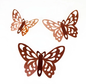 Macro detail of three 3D rose gold hollow butterfly wall stickers with intricate cutout patterns