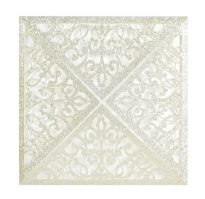 Macro view of square laser-cut wedding invitation with silver glitter filigree pattern