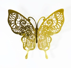 Close-up of golden hollow butterfly sticker with delicate lace-pattern metal texture