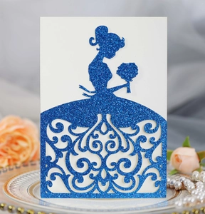 Detail of blue glitter laser-cut girl silhouette wedding invitation card on elegant plate