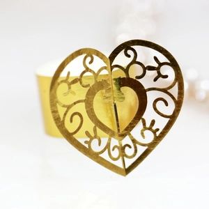 Elegant gold hollow heart napkin ring with ornate laser-cut pattern for wedding decor