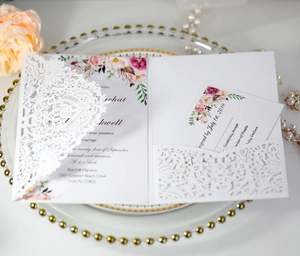 Detail of white laser-cut lace wedding invitation with purple floral RSVP card insert