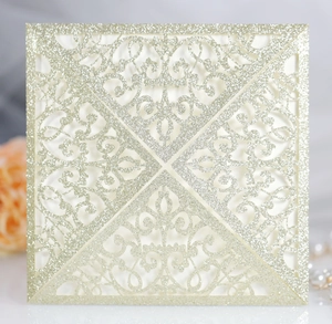 Detailed laser-cut champagne gold glitter invitation with elegant floral lace pattern