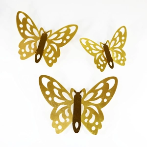 Detail of three golden 3D hollow butterfly wall stickers with intricate texture and metallic finish
