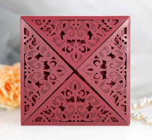 Detailed laser-cut floral patterns on a square burgundy wedding invitation suite
