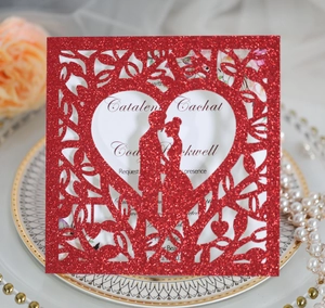 Détail de l'invitation de mariage rouge pailletée découpée au laser avec cœur et couple