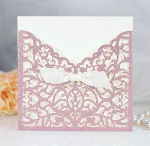 Dettaglio invito rosa glitterato tagliato al laser con elegante fiocco di raso bianco