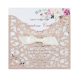 Dettaglio dell'invito di nozze glitter oro rosa con fiocco bianco e biglietto floreale