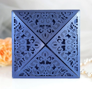 Macro detail of navy blue laser cut wedding invitation with intricate floral lace patterns