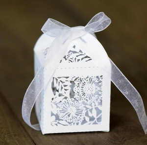 Detailed macro view of laser-cut floral hollow pattern on white wedding favor gift box
