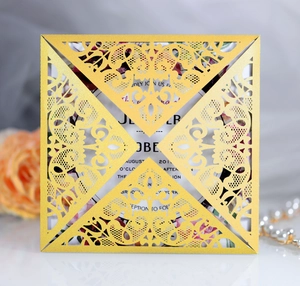 Detail of square gold laser-cut lace wedding invitation with pearl texture
