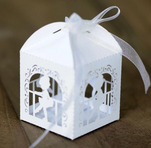 Laser cut white paper gift box featuring a bride and groom silhouette with a white ribbon bow