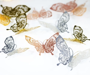 Macro view of 3D silver hollow butterfly wall stickers with detailed geometric lace patterns