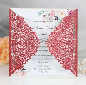 Close-up of red glitter laser-cut lace wedding invitation with elegant floral card insert