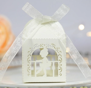 Close-up of laser-cut white ballerina favor box with elegant silver ribbon bow