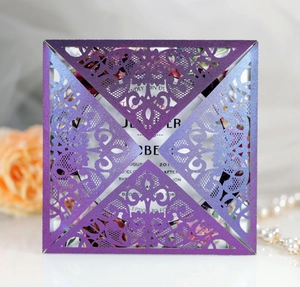Macro view of purple laser-cut wedding invitation showing delicate lace pattern