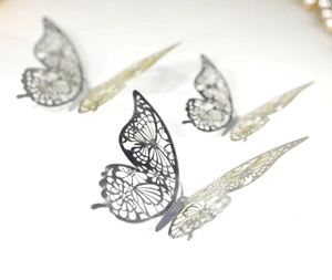Close-up of metallic silver hollow 3D butterfly wall stickers with intricate wing patterns