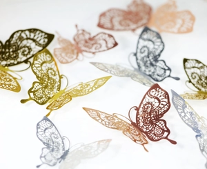 Macro shot of 3D laser-cut hollow butterfly wall stickers with detailed metallic textures