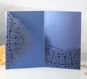 Macro view of navy blue laser-cut lace floral pattern on pearlescent wedding invitation