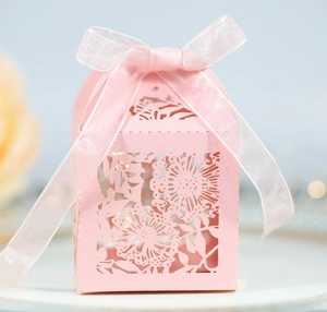 Pink laser cut wedding candy box with intricate floral patterns and soft chiffon ribbon