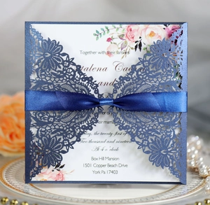 Detail of laser-cut wedding invitation with navy lace sleeve and floral inner card