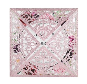 Close-up of laser-cut glitter wedding invitation featuring intricate floral hollow patterns