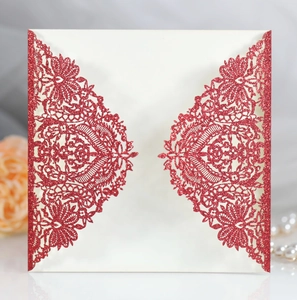 Macro detail of laser-cut lace pattern and red glitter powder on wedding invitation