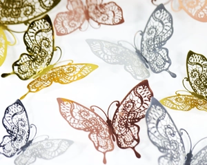 Macro detail of 3D silver lace butterfly stickers with hollow laser-cut floral patterns