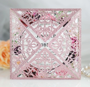 Detail of laser cut floral wedding invitation with gold glitter paper and floral inner card