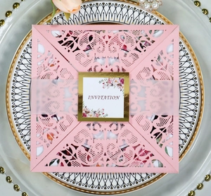 Detailed laser-cut pattern on pink invitation card with elegant floral inner page
