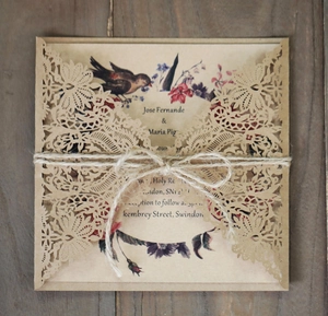 Macro view of laser cut kraft paper wedding invitation with hemp rope on wood surface