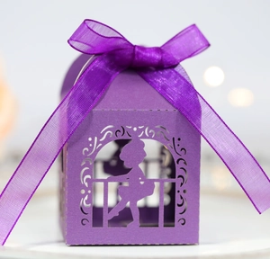 Detail of laser-cut purple gift box with a girl silhouette and organza ribbon bow