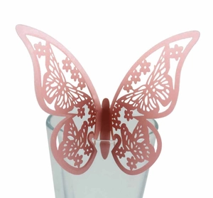 Détail macro du papillon en papier perlé rose découpé au laser pour décoration de verre
