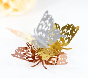 Macro shot of laser-cut 3D hollow butterfly wall stickers in gold silver and rose gold