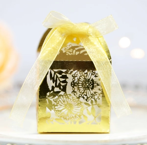 Detailed view of golden laser-cut wedding candy box with elegant floral hollow pattern