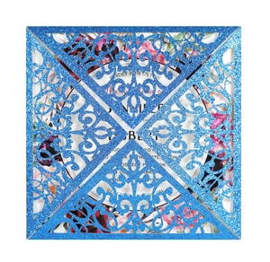 Detailed laser-cut pattern on blue glitter wedding invitation cover with floral card
