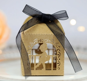 Detail of laser-cut ballerina silhouette on kraft paper candy box with black ribbon
