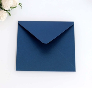 Detail of dark navy blue pearlescent envelope with classic V-flap on a white floral background
