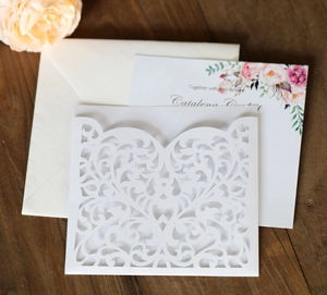 Detail of laser-cut heart invitation with elegant white floral inner card and envelope